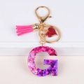 Detail of pink tassel and resin letter G keychain with sparkly glitter and heart charm - Letter G