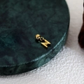 Polished golden letter N pendant accessory on an elegant dark green marble base - Letter Pendant (N) / Gold