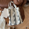 Detalle de un bolso tote de encaje blanco con delicados bordados de hojas negras finas - Bordado Floral Negro Beige
