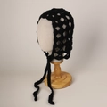 Detail of black crochet mohair hat featuring hollow knit pattern and long side straps - Black