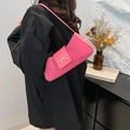 Pink baguette bag with bow metal detail on shoulder, worn by model in black outfit - Pink