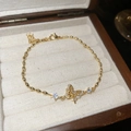 Nahaufnahme von 18k vergoldetem Armband mit Zirkon-Schmetterling und Olivenketten-Gliedern - Goldenes Mikro-Eingelegtes Zirkon-Schmetterlings-Armband