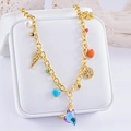 Golden planet necklace with purple heart pendant and charms on white jewelry box cushion - Heart