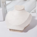 Macro detail of high-end bust jewelry stand with linen fabric and solid wood base - Beige