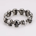 Primer plano de pulsera de calaveras en plata antigua con acabados metálicos detallados - Color Acero