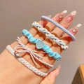 Girl's elastic hair ties in blue, pink, and beige with bows and heart charms on a hand - Blue Mix