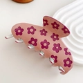 Haarklammer aus pinkem Acetat mit violettem Blumenmuster auf einem weißen Tablett - Rosa-Gänseblümchen