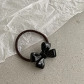 Chic black acrylic bow hair tie with dark brown elastic band on minimalist background - Black