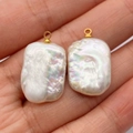 Irregular baroque freshwater pearl pendants with gold loops held in hand for jewelry making - Freshwater Pearl