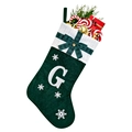 Detail of green velvet Christmas stocking with white knit cuff and embroidered letter G - Green G