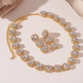 Macro detail of gold-plated halo jewelry set with round crystals and pavé diamonds - 2-Piece Set (Necklace + Stud Earrings) / Gold Square Style