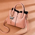 Sac à main chic en cuir PU rose avec breloque papillon et chaîne en métal sur fond chaud - Rose