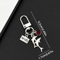 Silver ocean dolphin keychain with red gemstone and wish tag on a black background - Ancient Silver Dolphin Keychain-ER468