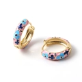 Dettaglio di orecchini a cerchio dorati con smalto rosa e motivo floreale blu su bianco - No.03 - Floreale rosa blu