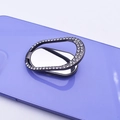 Close-up of a black oval diamond-encrusted metal ring holder on a purple phone case - Black