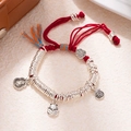Close-up of red braided bracelet with silver rings, lucky cat and fortune coin charms - L312-1 Fortune Cat (Red Rope)