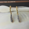 Detailed macro view of irregular gold earrings featuring sparkling rhinestone pavé detail - Gold