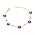 Detail of gold chain bracelet featuring dark blue beaded flowers and adjustable clasp - Blue Bracelet