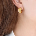 Pendientes de aro dorados en forma de C con textura martillada vintage en una modelo - Dorado