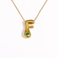Detail of 18k gold plated bubble letter F pendant with a green heart gemstone - Letter F