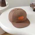 Detailansicht der orangen Stickerei auf einer dunkelbraunen Hip-Hop-Cap für Kinder - 52-54cm (3-8 Jahre) / Braun
