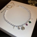 Baroque pearl necklace detail with gold charms including smiley face and heart pendants - Multi-Pendant Pearl Style