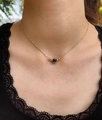 Primo piano della collana a strati dorata con ciondolo malocchio su modella - Collana di Perline Minimalista Occhio del Diavolo