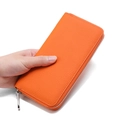 Genuine leather long zip wallet in vibrant orange with litchi grain texture held in hand - 20x2.5x10cm / Orange