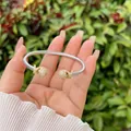 Dettaglio del bracciale a cavo ritorto con estremità in oro e cristalli sulla mano - Stile Nodo a Croce con Sfera Dorata (1)