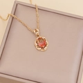Close-up of golden sunflower pendant with colorful gems and diamonds in a jewelry box - Rose Red