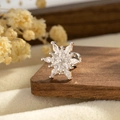 Silver snowflake earrings with sparkling zircons displayed on a dark wood background - Kite Zircon Snowflake (A996-1)