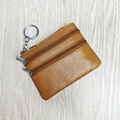 Brown genuine leather coin purse with lychee texture and dual zippers in bird's eye view - Earthy Yellow