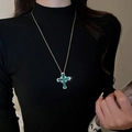 Detail of a gold cross necklace with a large green emerald-cut stone worn on black fabric - Green Gemstone Cross Style (34#)