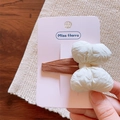 Close-up of a cream-colored crinkle bow hair clip on a soft pink display card - Hair Clip / Beige