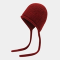 Vista detallada del gorro de punto rojo oscuro con textura suave y orejeras de trenza - Talla única / Burdeos