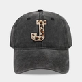 Close-up of leopard print letter J embroidery on washed black cotton baseball cap - Letter J