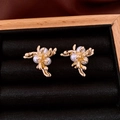 Dettaglio orecchini a ramo di corallo dorato con perle bianche su velluto nero - Stile Grappolo di Fiori di Corallo / Oro