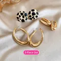 Detailed set of leopard print studs and gold hoop earrings on champagne silk background - 3-Piece Set (Leopard Disc + Gold Ear Clip + Large Oval)
