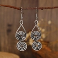 Zilveren spiraalvormige oorhangers in retro boho-stijl op houten achtergrond - Antiek Zilver N-692