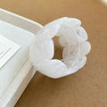 Close-up of white marble pattern acrylic wide stretch bracelet on a soft fabric display - White