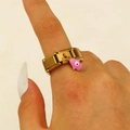 Detail eines goldenen Modulrings mit rosa Emaille-Hamsa-Hand und Evil Eye-Anhänger am Model - 18 Karat Vergoldeter Rosa Hand Der Fatima Anhänger Ring (A-667)