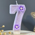 Glittery purple number 7 birthday candle with floral decor on a wooden base - Number 7