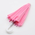 Detailed view of a pink miniature doll umbrella with a white curved handle for 18-inch dolls - Pink