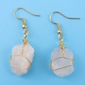Macro shot of handmade wire-wrapped pink raw crystal earrings with gold finish - Gold + Rose Quartz