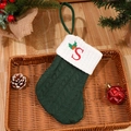 Green knitted Christmas stocking featuring a red embroidered letter S with holly detail - Letter S