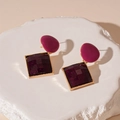 Detalle de pendientes geométricos retro en magenta y violeta sobre base de piedra - Colgante Geométrico de Contraste Rosa y Morado (Pin de Plata)