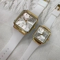 Detalle de dos relojes cuadrados dorados con correas de silicona blanca sobre tela - Pequeño / Esfera Blanca Correa Blanca