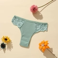 Gros plan d'une culotte en coton côtelé vert menthe avec dentelle sur fond chaleureux - Vert Haricot