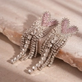 Vista macro di nappe a cuore rosa con strass su una superficie in pietra - Perno in Argento 925 - Orecchini a Nappa a Cuore Rosa