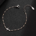Detail of stainless steel cross charm bracelet with pale pink beads on dark surface - Silver-Pink